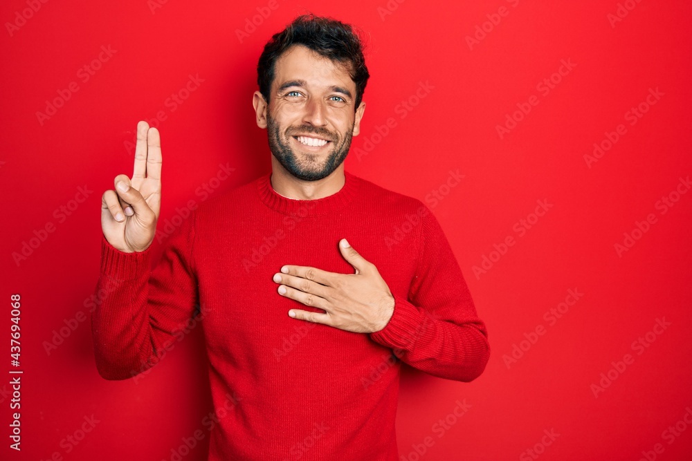 Handsome man with beard wearing casual red sweater smiling swearing with hand on chest and fingers up, making a loyalty promise oath Handsome man with beard wearing casual red sweater smiling swearing with hand on chest and fingers up, making a loyalty promise oath