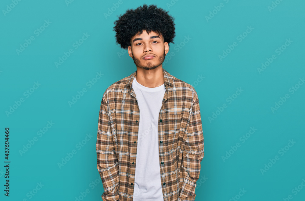 Young african american man with afro hair wearing casual clothes depressed and worry for distress, crying angry and afraid. sad expression. Young african american man with afro hair wearing casual clothes depressed and worry for distress, crying angry and afraid. sad expression.