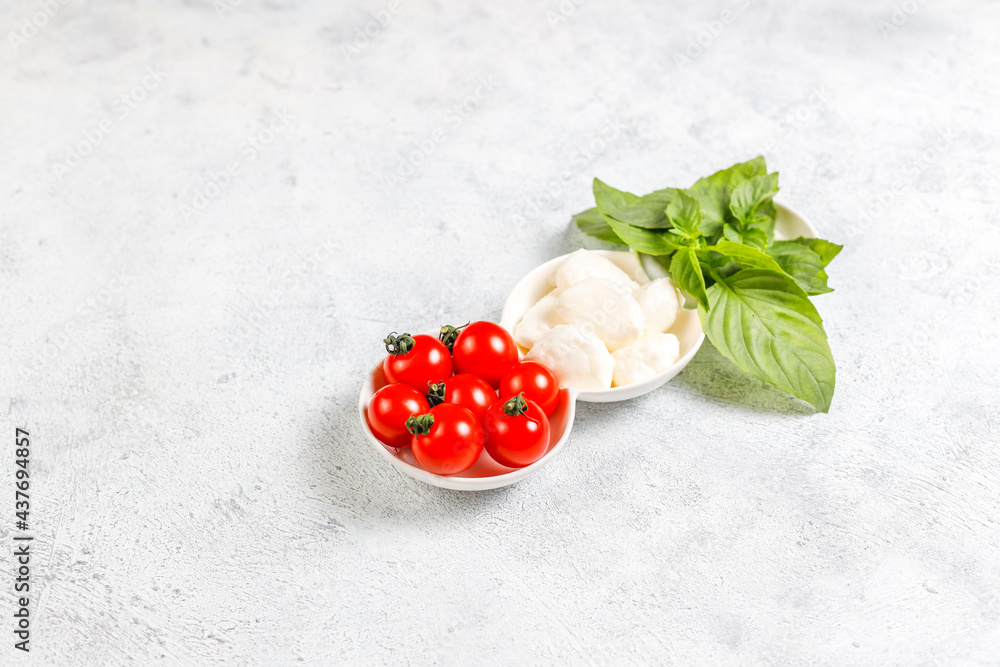 Delicious Italian caprese salad with sliced red and orange cherry tomatoes and mozzarela balls. Delicious Italian caprese salad with sliced red and orange cherry tomatoes and mozzarela balls.