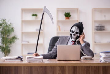 Devil businessman employee sitting at workplace