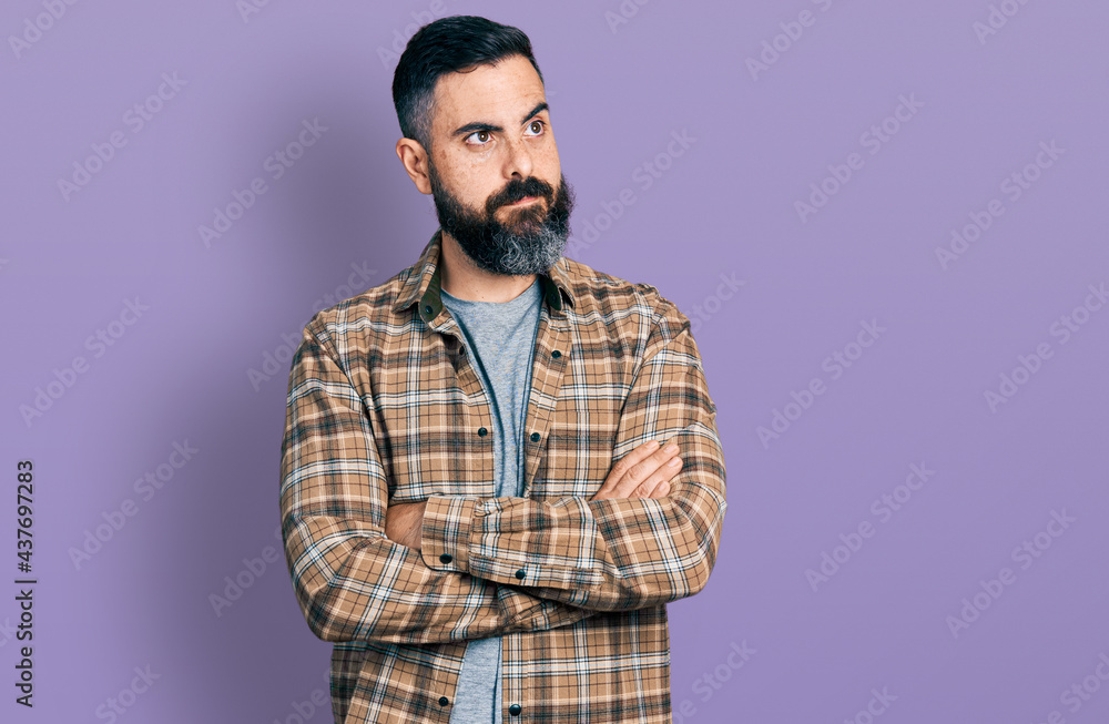 Fototapeta premium Hispanic man with beard with arms crossed gesture smiling looking to the side and staring away thinking.