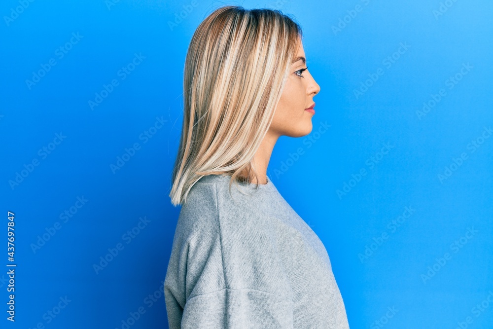 Beautiful blonde woman wearing casual clothes looking to side, relax profile pose with natural face with confident smile. Beautiful blonde woman wearing casual clothes looking to side, relax profile pose with natural face with confident smile.