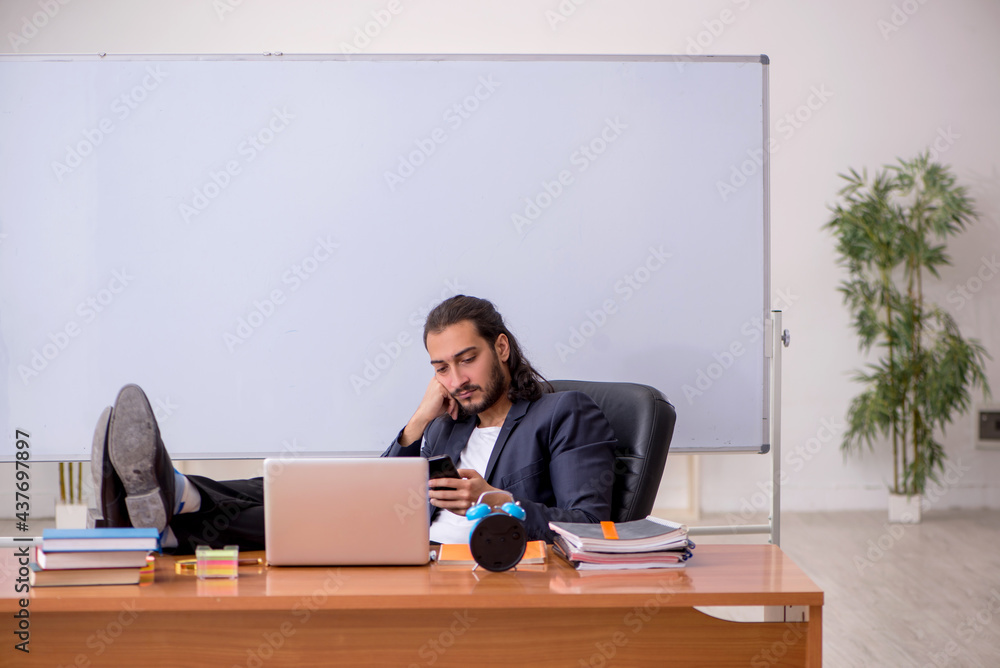Young male teacher in the classroom Young male teacher in the classroom