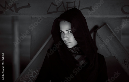 Black and white portrait of a young beautiful woman in a black hood photo