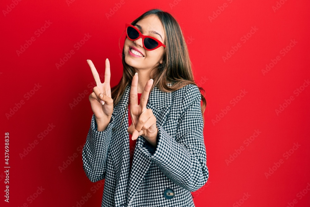 Young brunette woman wearing fashion and modern look smiling looking to the camera showing fingers doing victory sign. number two. Young brunette woman wearing fashion and modern look smiling looking to the camera showing fingers doing victory sign. number two.