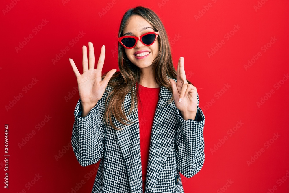 Young brunette woman wearing fashion and modern look showing and pointing up with fingers number eight while smiling confident and happy. Young brunette woman wearing fashion and modern look showing and pointing up with fingers number eight while smiling confident and happy.
