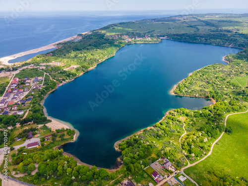Aerial view of the lake on the sea coast and forest made with drone on the Baltic sea, Yantarny, Russia