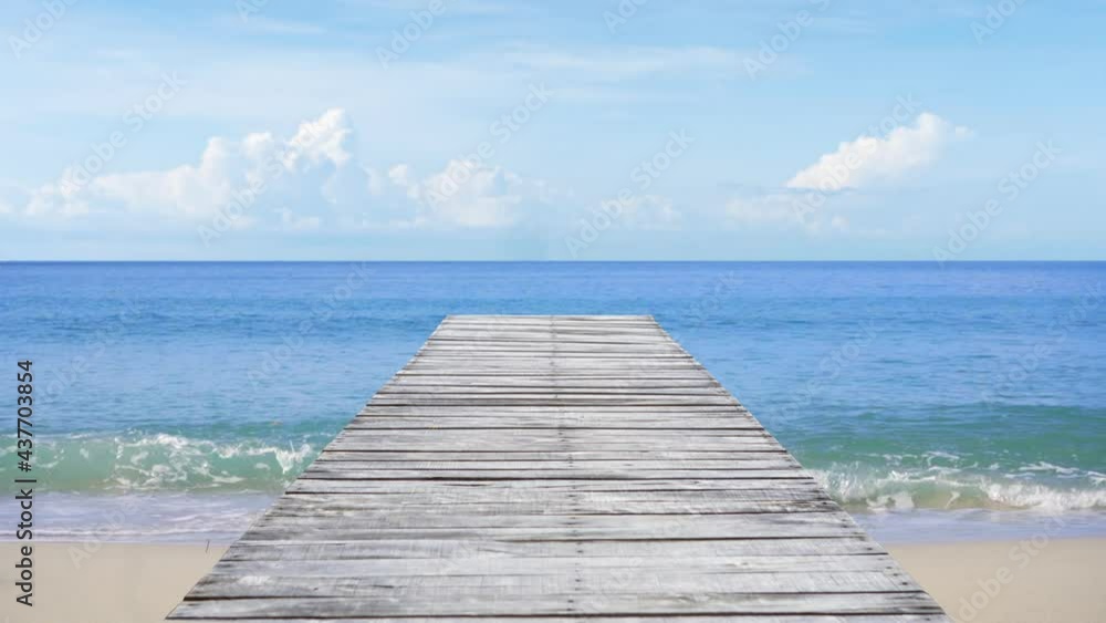 The white wooden bridge stretches out into the calm sea. The white wooden bridge stretches out into the calm sea.