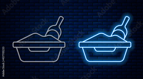 Glowing neon line Cat litter tray with shovel icon isolated on brick wall background. Sandbox cat with shovel. Vector