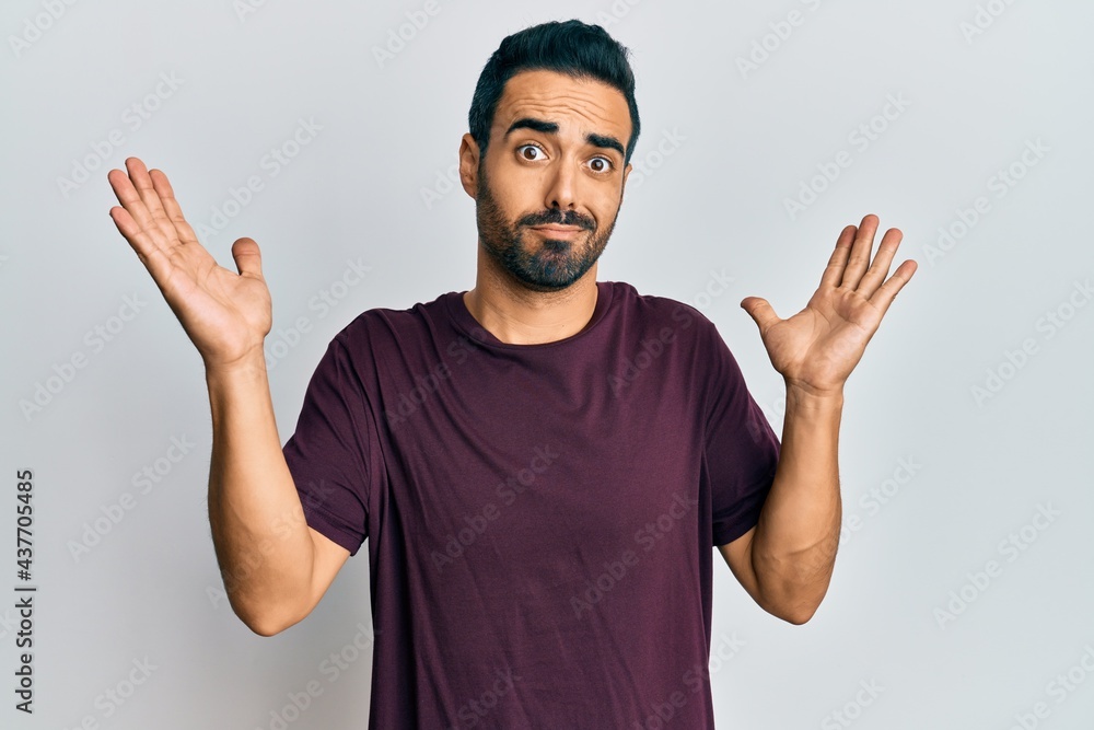Young hispanic man wearing casual clothes clueless and confused with open arms, no idea and doubtful face. Young hispanic man wearing casual clothes clueless and confused with open arms, no idea and doubtful face.