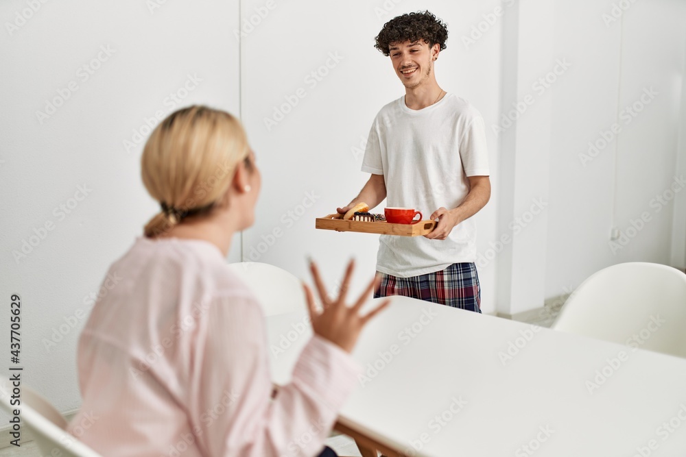 Fototapeta premium Man surprising his girlfriend with breakfast at home.