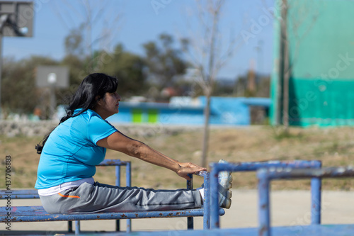 Mexican aged woman training on a playground