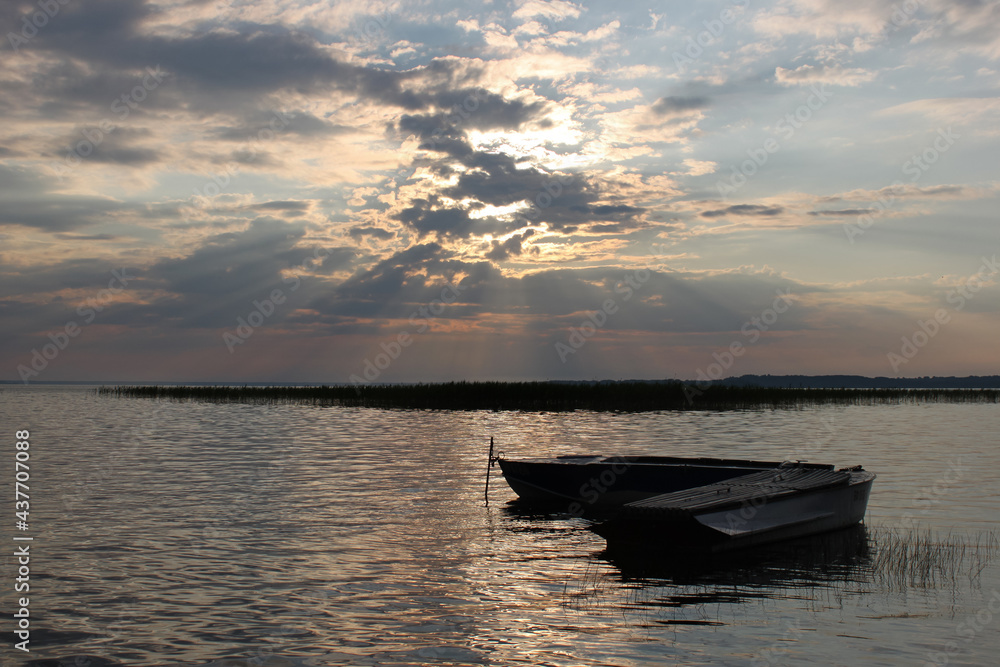 Tranquil and romantic landscape with two row boats on the background of the sunset Tranquil and romantic landscape with two row boats on the background of the sunset