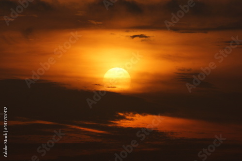 Sun rises illuminating the sky with orange color