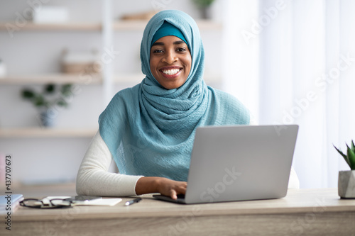 Freelance. African Muslim Woman In Hijab Working With Laptop At Home Office