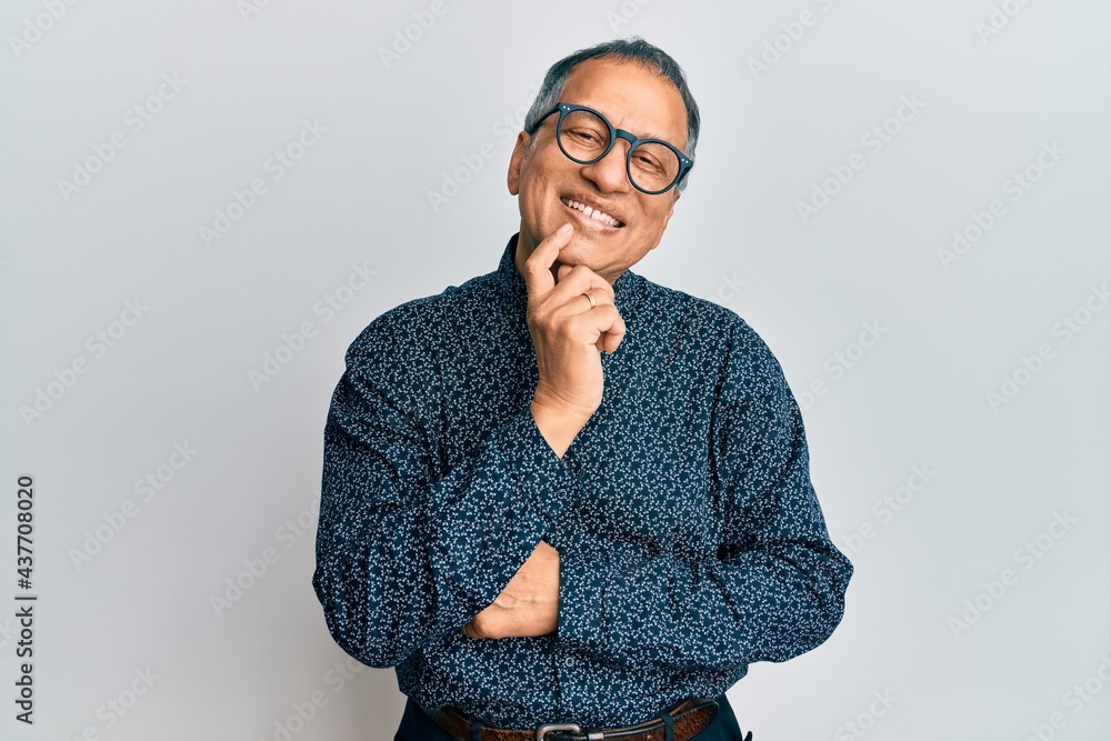 Middle age indian man wearing casual clothes and glasses smiling looking confident at the camera with crossed arms and hand on chin. thinking positive. Middle age indian man wearing casual clothes and glasses smiling looking confident at the camera with crossed arms and hand on chin. thinking positive.
