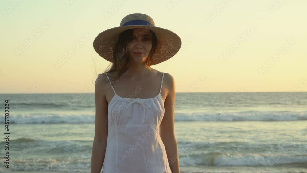 Portrait of a closeup of a young tender ropmantic girl in a hat on the shower of the Pacific. Woman in a white dress at sunset. soft light. Portrait of a closeup of a young tender ropmantic girl in a hat on the shower of the Pacific. Woman in a white dress at sunset. soft light.