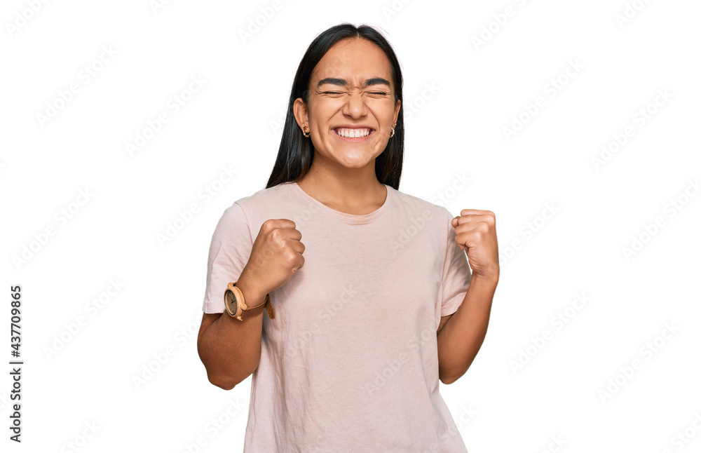 Young asian woman wearing casual clothes excited for success with arms raised and eyes closed celebrating victory smiling. winner concept. Young asian woman wearing casual clothes excited for success with arms raised and eyes closed celebrating victory smiling. winner concept.