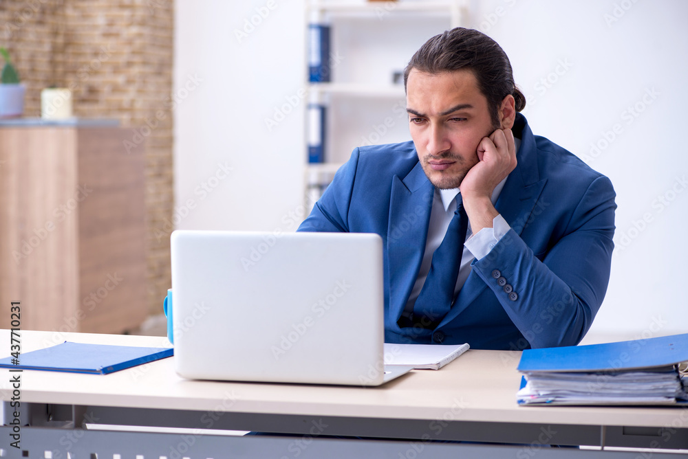 Young male employee working at workplace Young male employee working at workplace