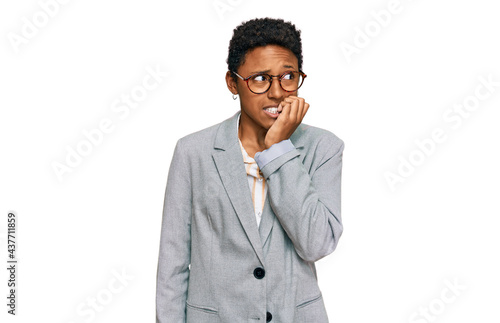 Young african american woman wearing business clothes looking stressed and nervous with hands on mouth biting nails. anxiety problem.