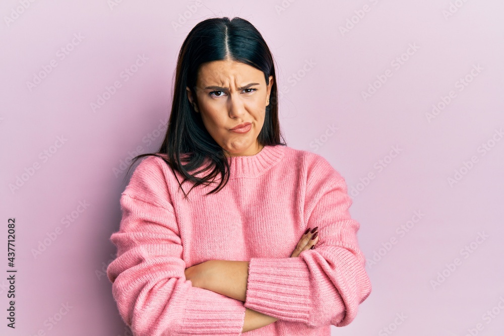 Beautiful brunette woman wearing casual winter sweater skeptic and nervous, disapproving expression on face with crossed arms. negative person. Beautiful brunette woman wearing casual winter sweater skeptic and nervous, disapproving expression on face with crossed arms. negative person.