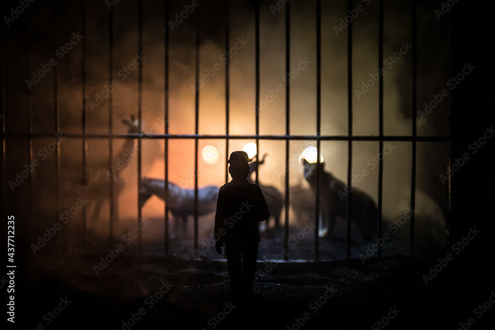 People and animals on opposite sides of the fence concept. Creative decoration with toy figures. Burning colorful background.