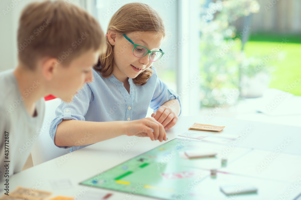 Happy cute children playing board games and having fun at home Happy cute children playing board games and having fun at home