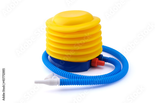A yellow and blue plastic foot pump with a long ruffled hose and a white nozzle isolated on a clean white background with soft shadows.
