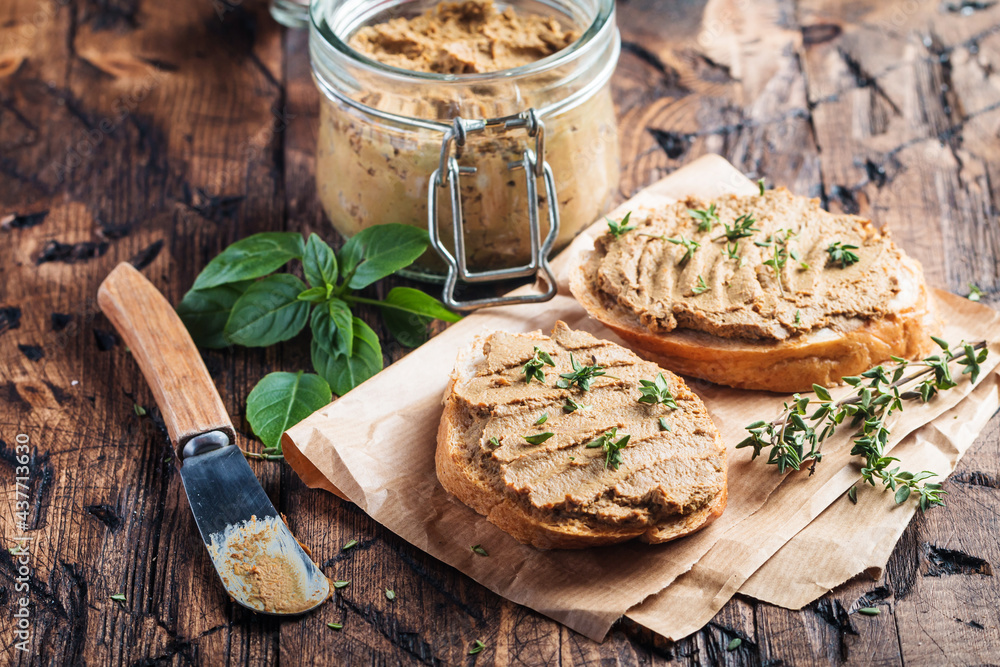Fresh homemade chicken liver pate on bread over rustic background Fresh homemade chicken liver pate on bread over rustic background