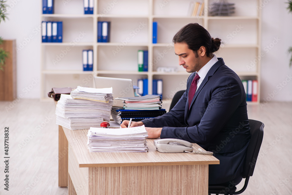 Young male employee unhappy with excessive work Young male employee unhappy with excessive work