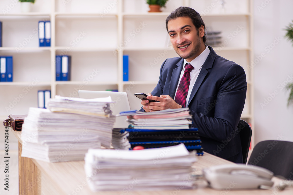 Young male employee unhappy with excessive work Young male employee unhappy with excessive work