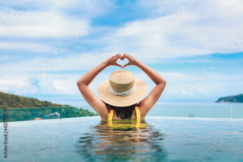 Asian travel bikini woman relax in infinity pool resort on phuket beach Thailand photo