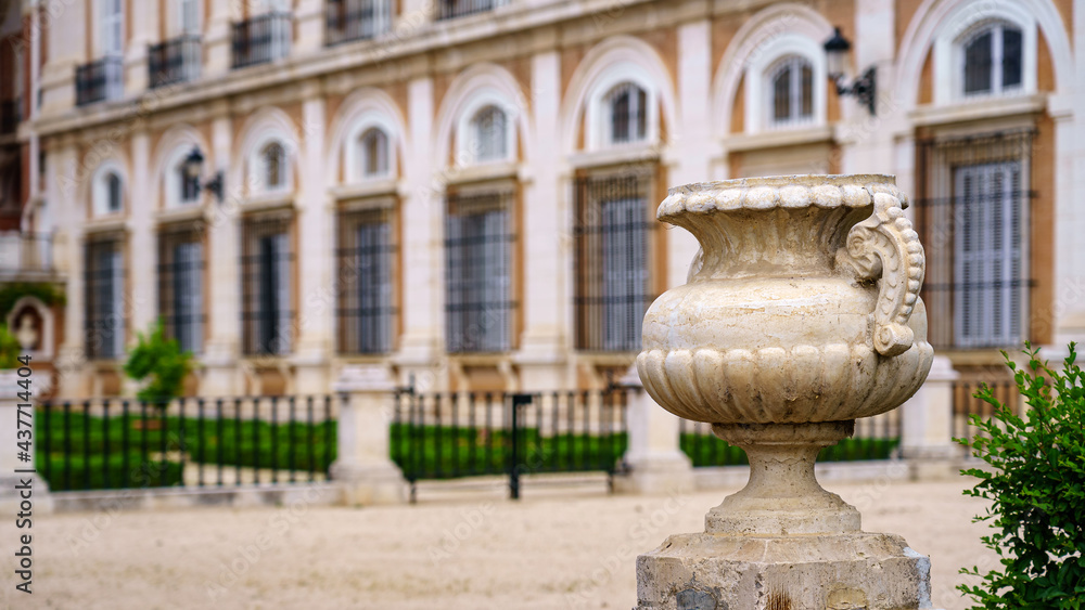 Royal palace garden with detail of ancient stone vase sculpture.