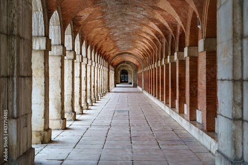 Large symmetrical exterior corridor with arches and columns in the old royal palace of Aranjuez. photo