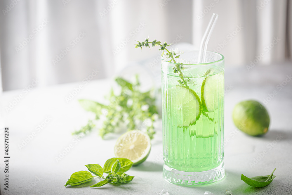 Fototapeta premium Summer green drink, lemonade with lime, basil and ice in a glass