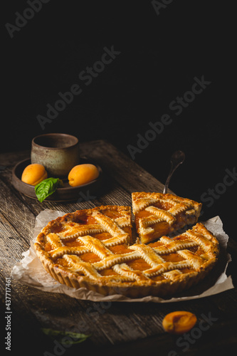 Summer homemade apricot or peach pie on dark wooden background. Delicious fruit dessert. Fruit cake. photo