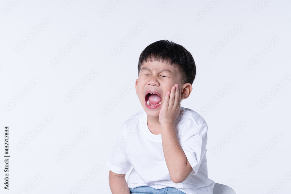 Asian boy touching his pain cheek from toothache Asian boy touching his pain cheek from toothache
