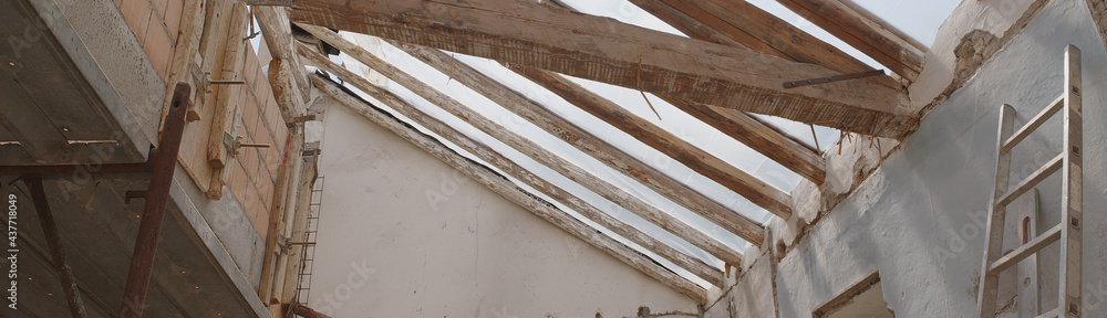 construction building site with the wooden old beams roof, reinforced concrete beam and brick, scaffolding and wall with ladder, renovation house project plan, work concept