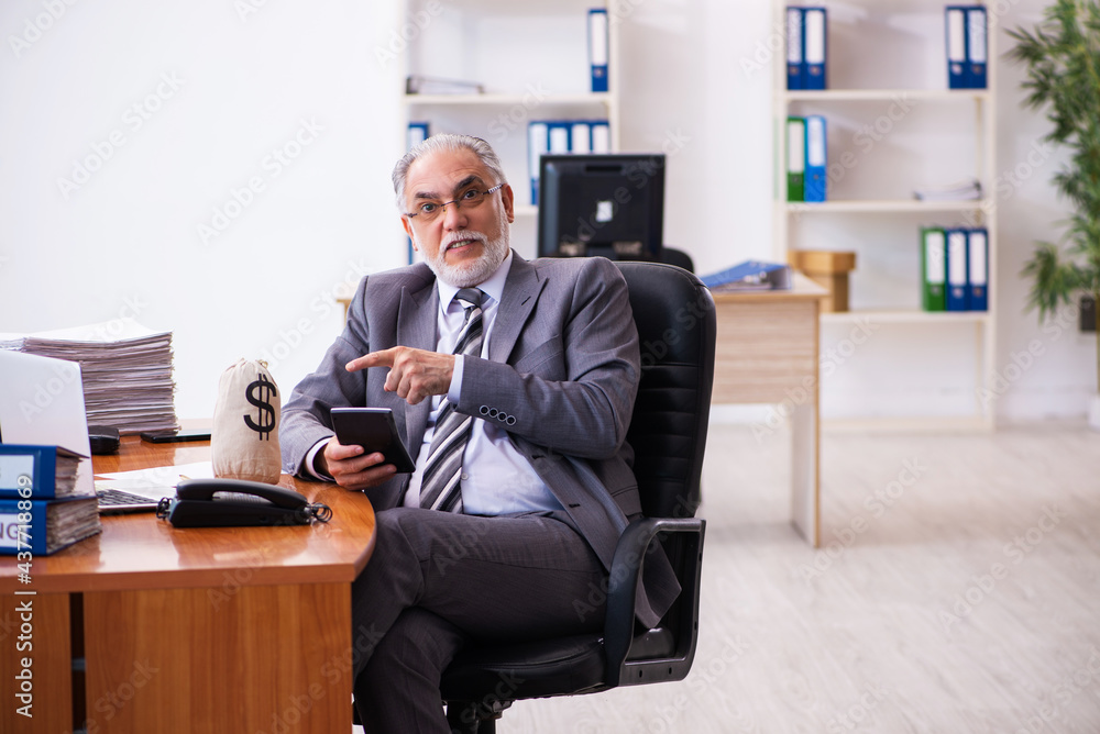Old male businessman employee holding moneybag in the office Old male businessman employee holding moneybag in the office