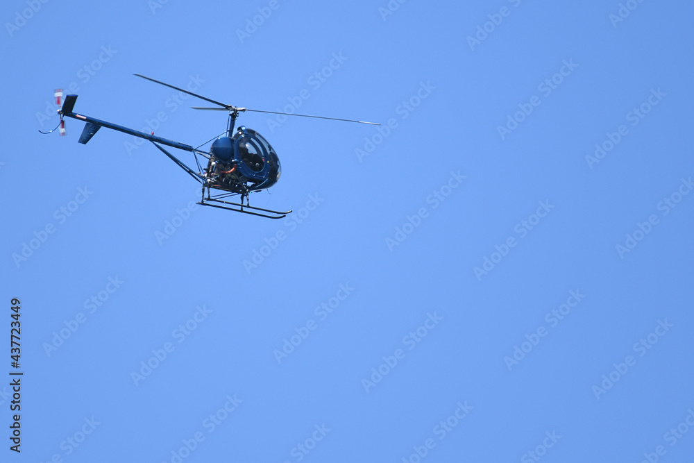 Helicopter flying under a blue sky