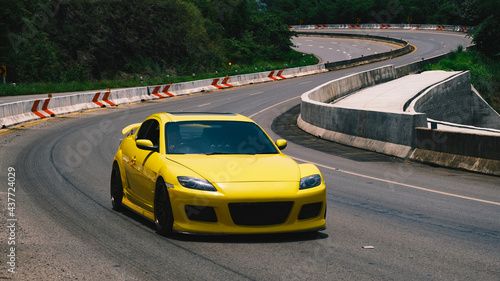 Φωτογραφία Chiang Mai, Thailand - May 31, 2021: Mazda RX-8 Yellow on the asphalt road with forest and high-speed highway , Wankel (Rotary) Engine fully modified with Brembo brake and top secret parts and etc