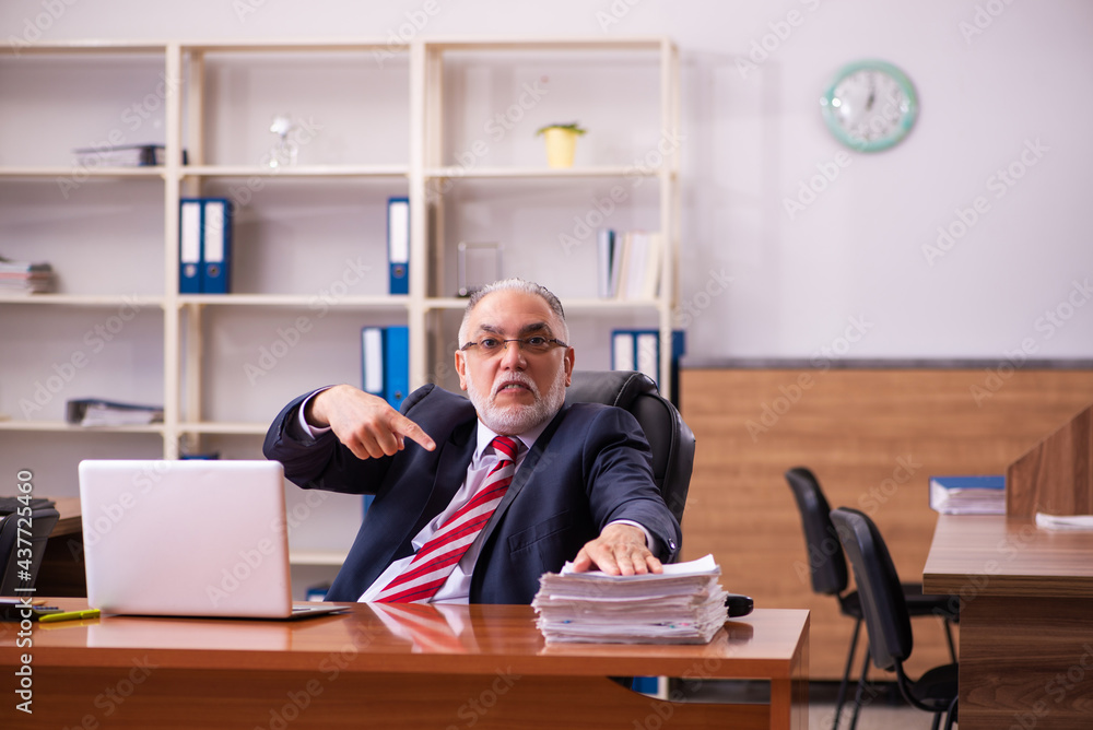 Old male employee sitting in the office Old male employee sitting in the office