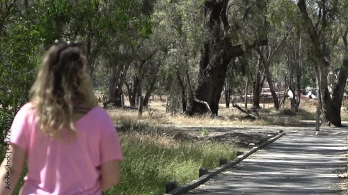 Outdoor nature blonde woman walking in nature along bridge photo