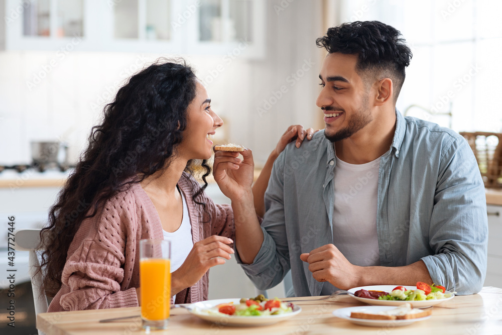 Happy young arab couple enjoying eating their breakfast together at home Happy young arab couple enjoying eating their breakfast together at home
