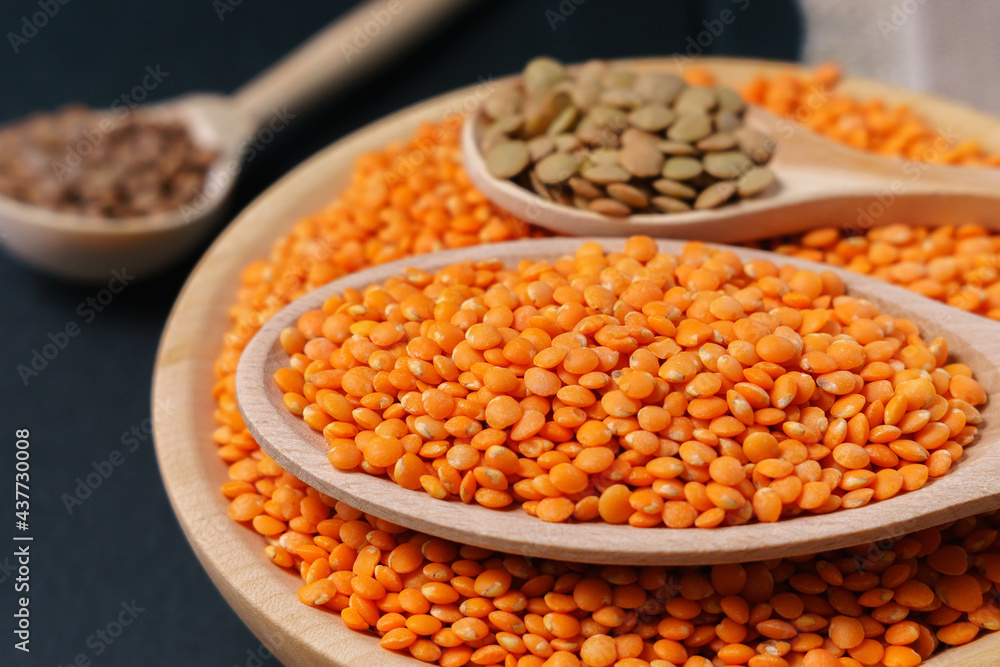 wooden bowl red lentils Lens culinary against a dark background. Selective focus wooden bowl red lentils Lens culinary against a dark background. Selective focus
