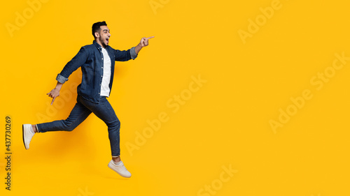 Excited middle-eastern man running towards copy space
