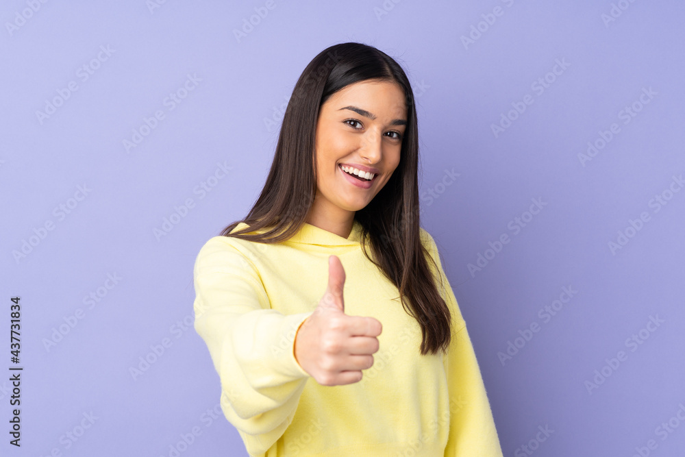Young caucasian woman over isolated background with thumbs up because something good has happened Young caucasian woman over isolated background with thumbs up because something good has happened
