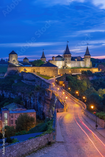 Night view of illuminated Old Town and Kamianets-Podilskyi Castle, a medieval fortress featuring several original towers.
