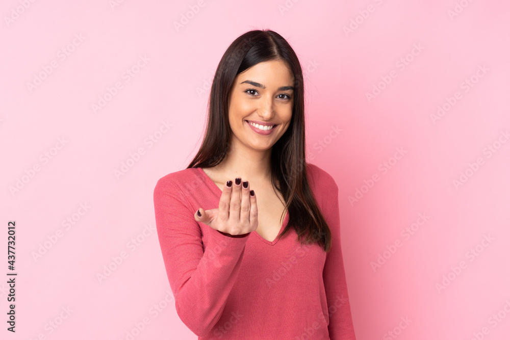 Young caucasian woman over isolated background inviting to come with hand. Happy that you came Young caucasian woman over isolated background inviting to come with hand. Happy that you came