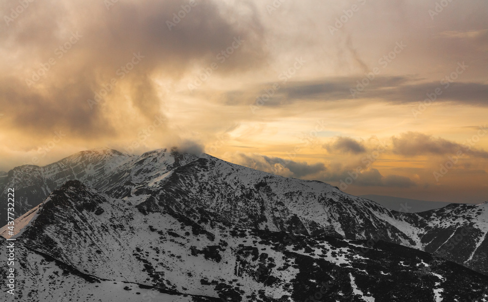 Winter Snowy Mountain Scenery. Mountainside Covered by Snow. Cloudy Evening Sky. Landscape Without People. Early Winter.Windy Weather. Clouds Blown by the Wind Over the Summit. Sunset. Tatras, Poland.